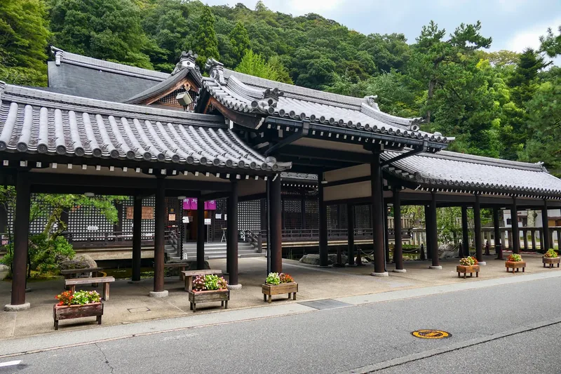 The tiled roof and wooden entrance of Goshono-yu bathhouse in Kinosaki Onsen